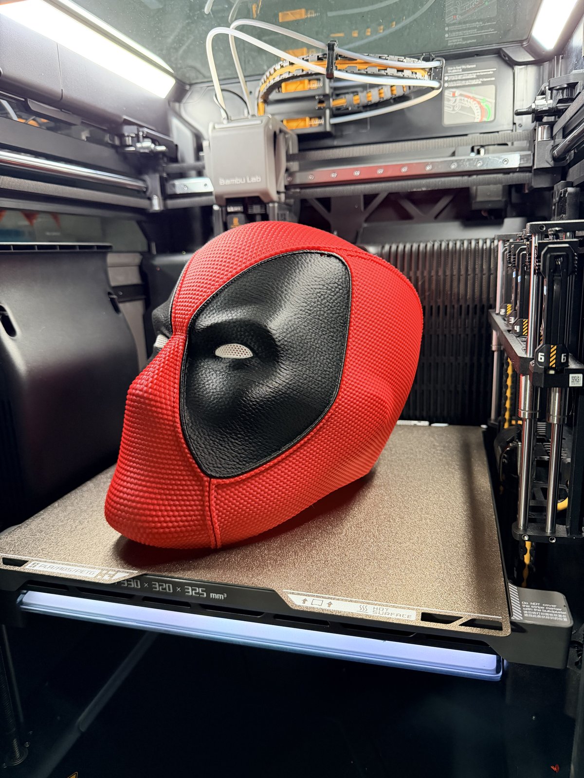 Red and black Deadpool-style mask in profile view