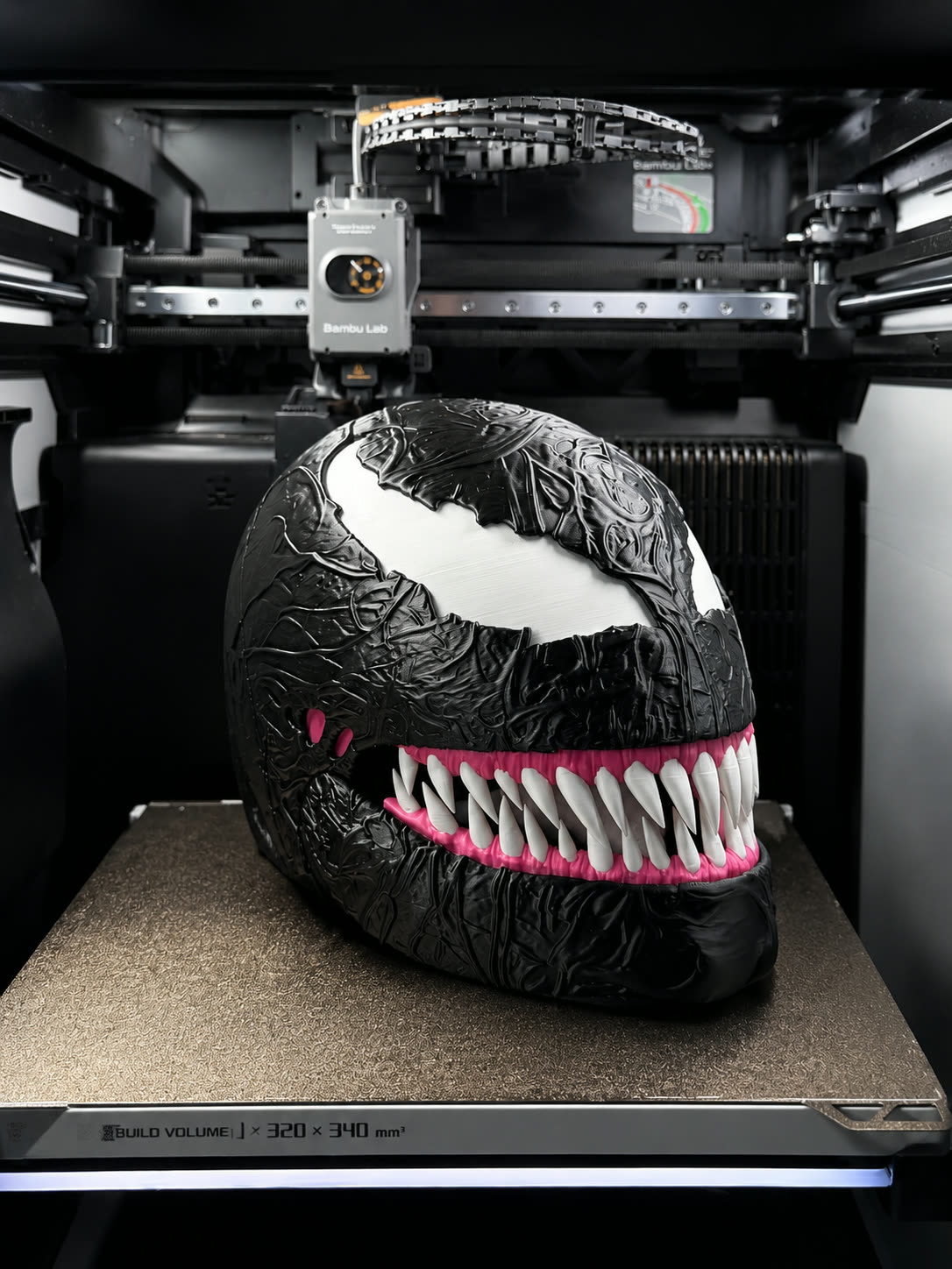 Glossy black 3D printed creature mask with jagged white teeth