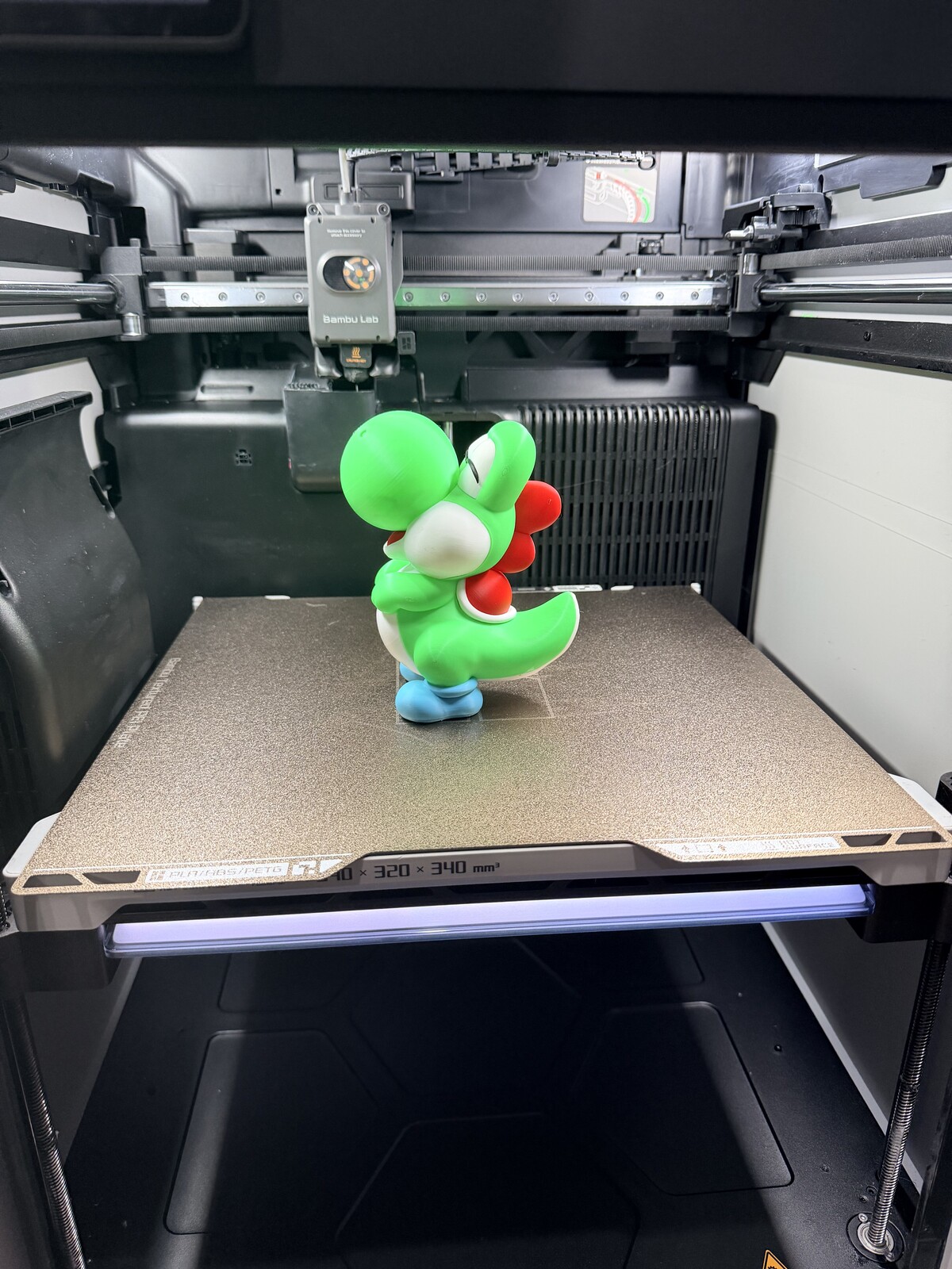 Green dinosaur character figure with a red shell backpack