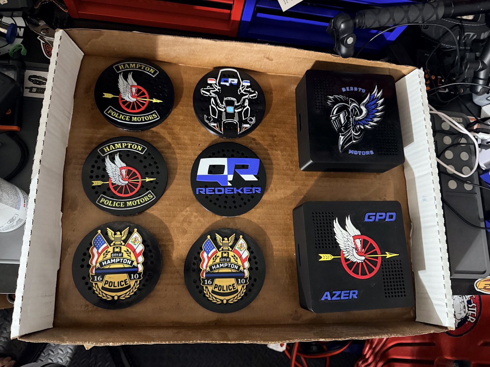 Box of police siren covers with individual unit insignias