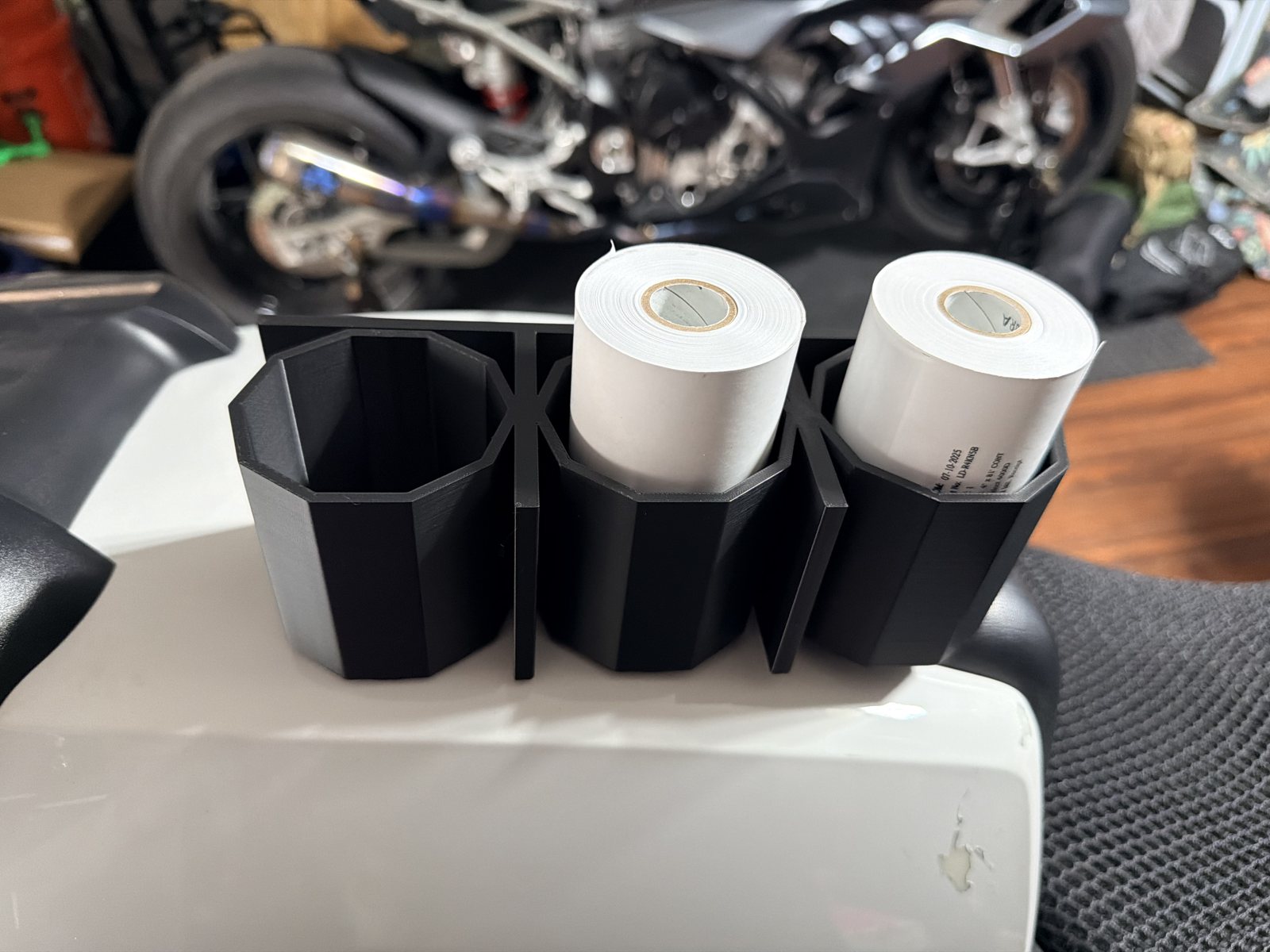 Black printed organizer holding two cylindrical parts