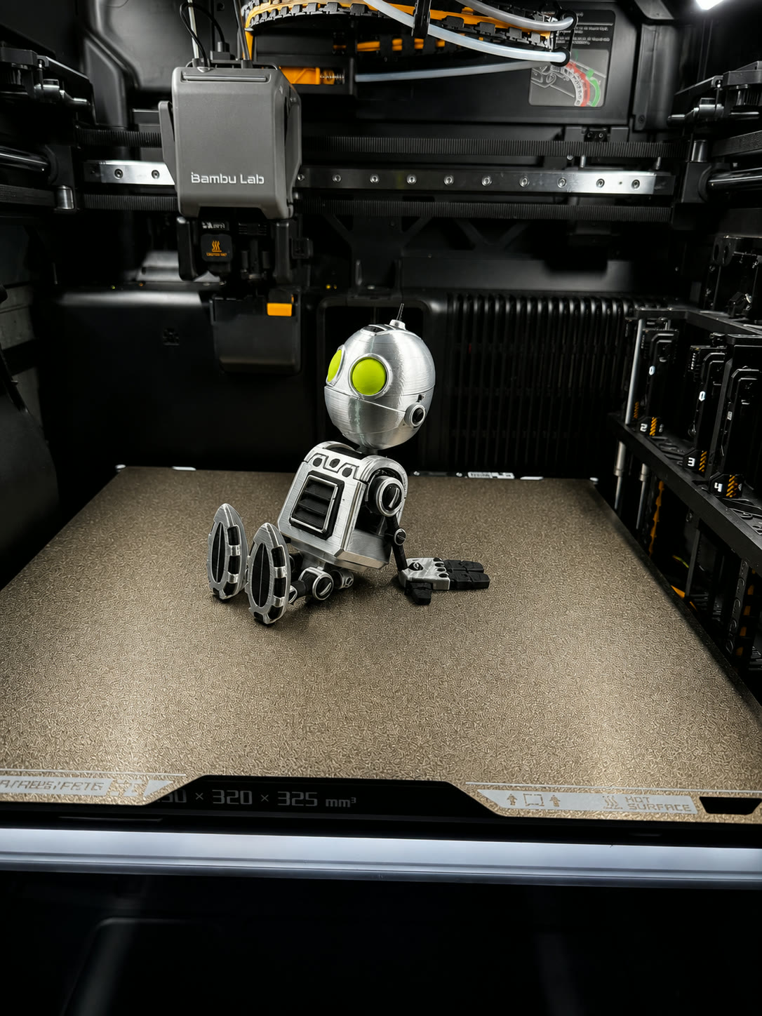 Small white robot figure fresh off the print bed