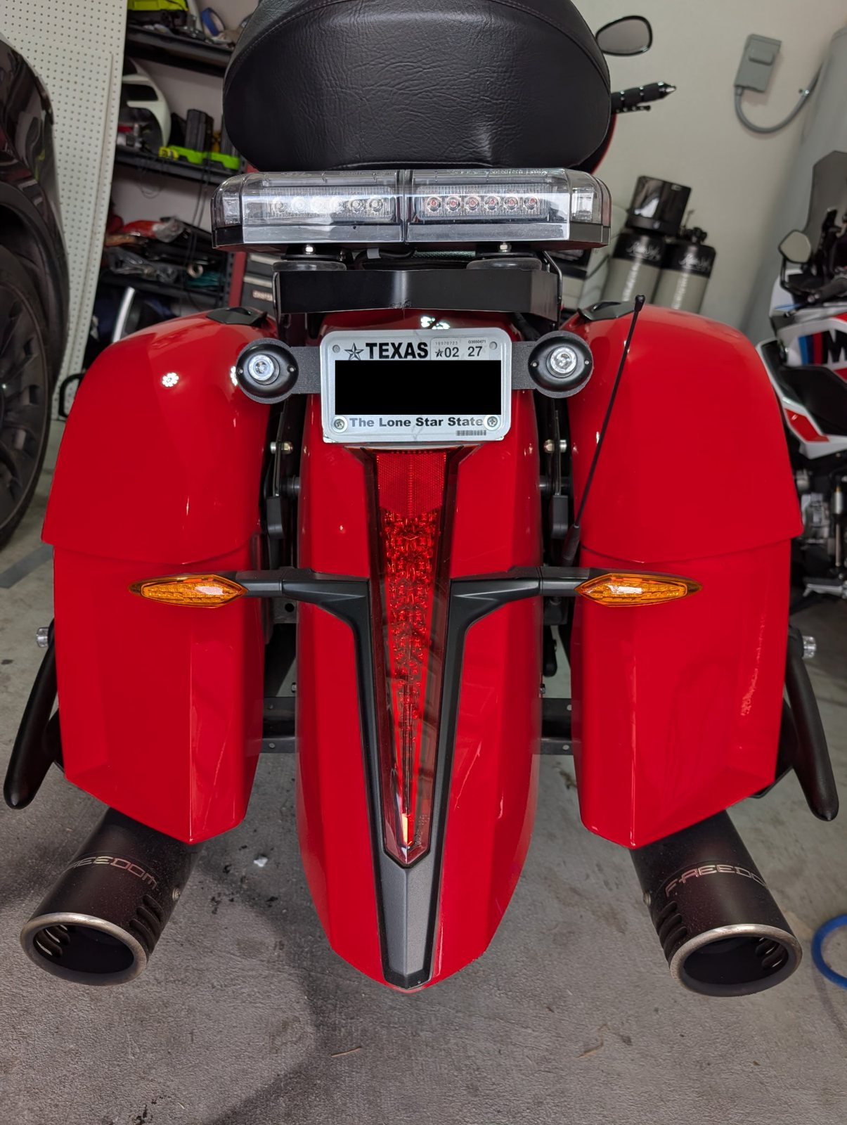 Rear of a red motorcycle fitted with custom accessories