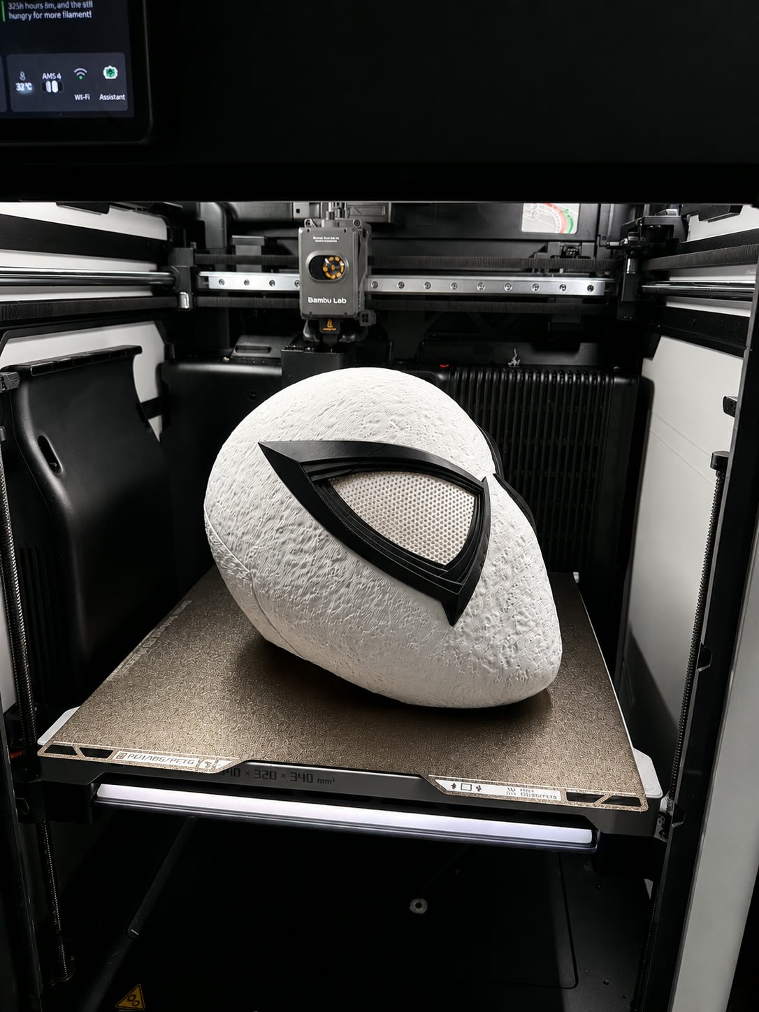White sci-fi helmet with a black V-shaped visor, printed in place on the printer bed