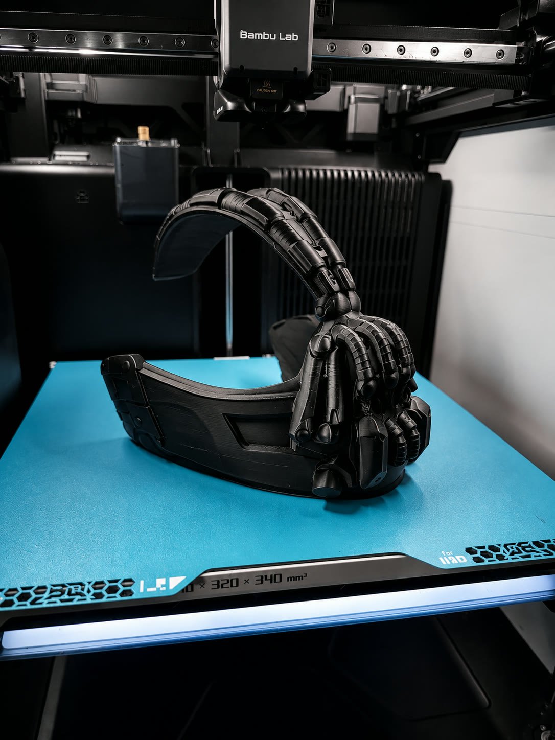Black helmet with sculpted claw details on a blue print plate