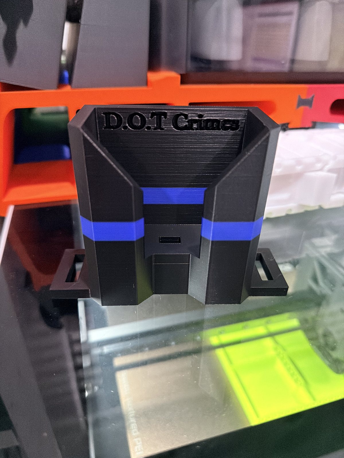 Black and blue printed holder on a 3D printer bed