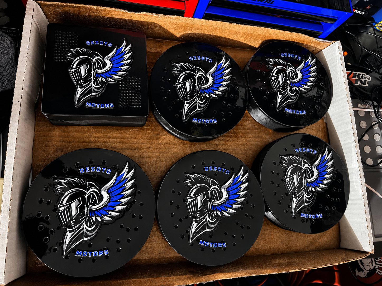 Box of black siren covers with blue winged motor unit emblems