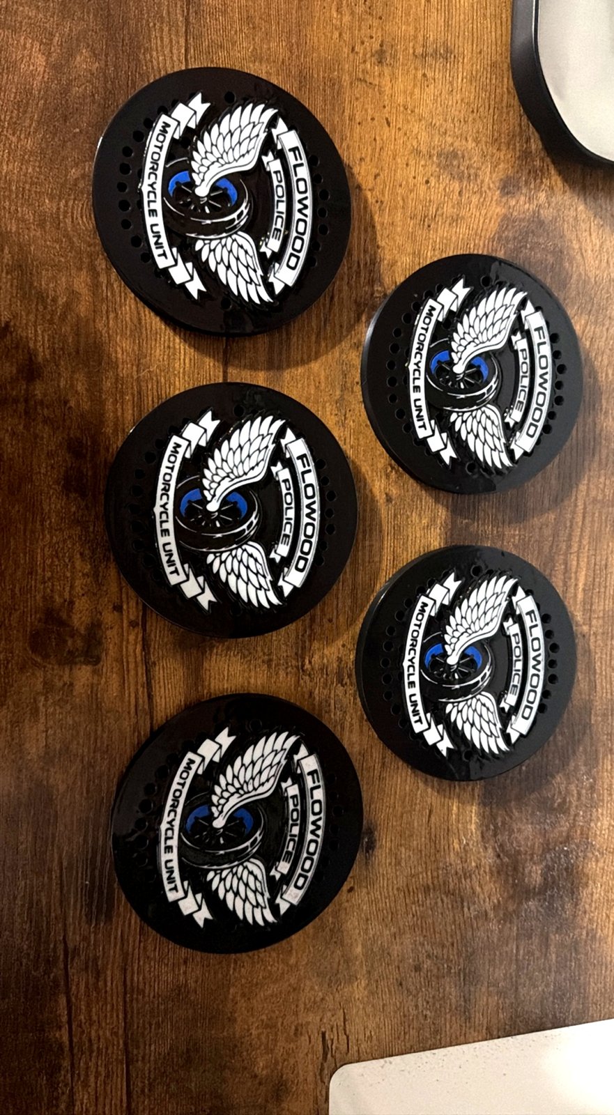 Four black siren covers with white police emblems