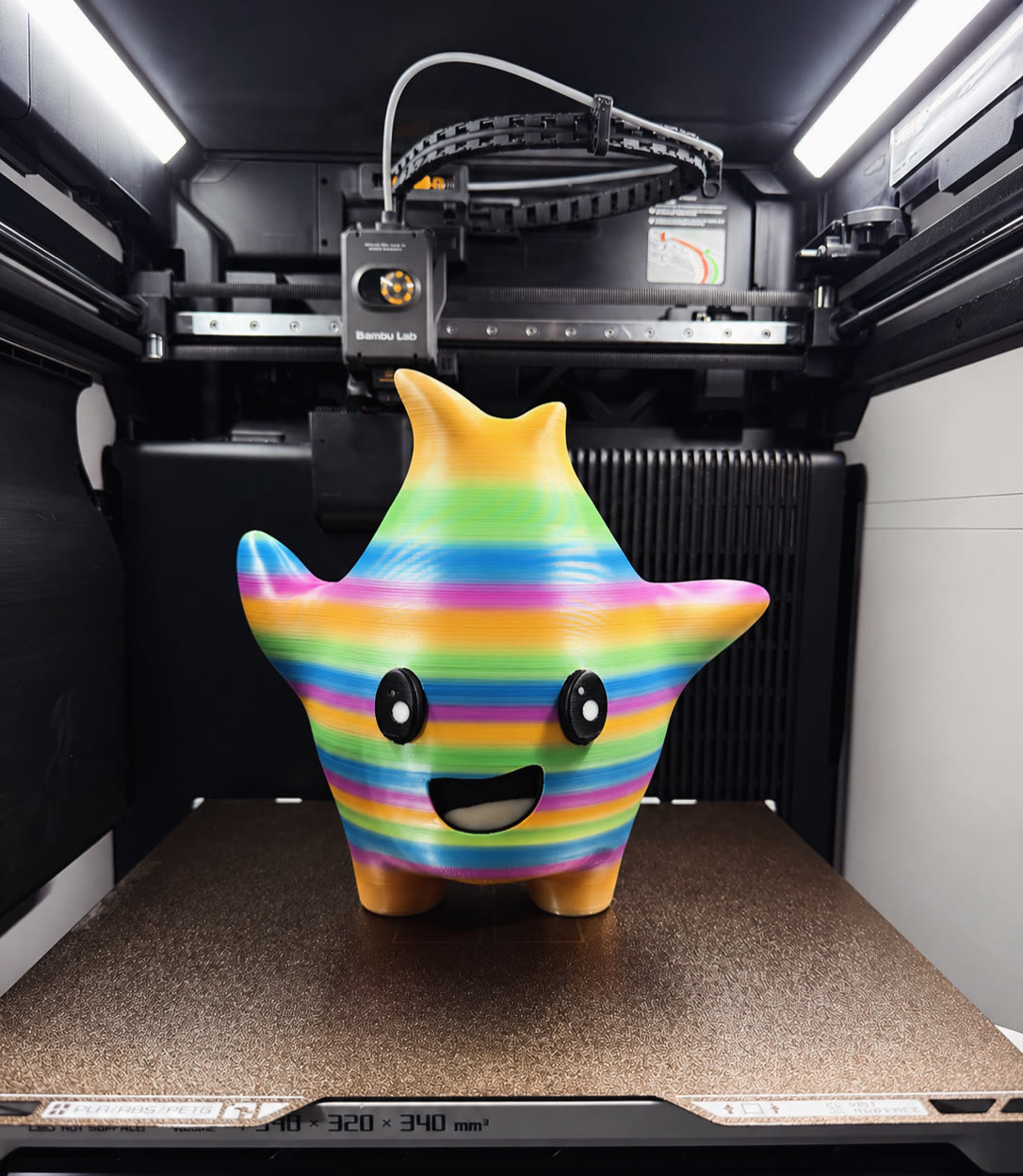 Rainbow-colored star character figure with a painted face