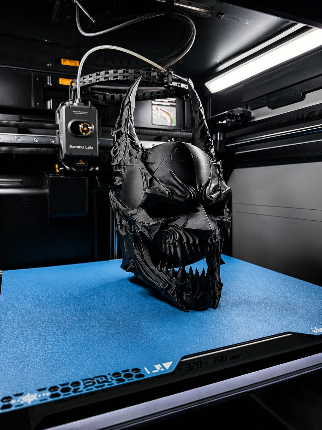 Matte black monster helmet with angular blade-like visor plates, fresh off the printer