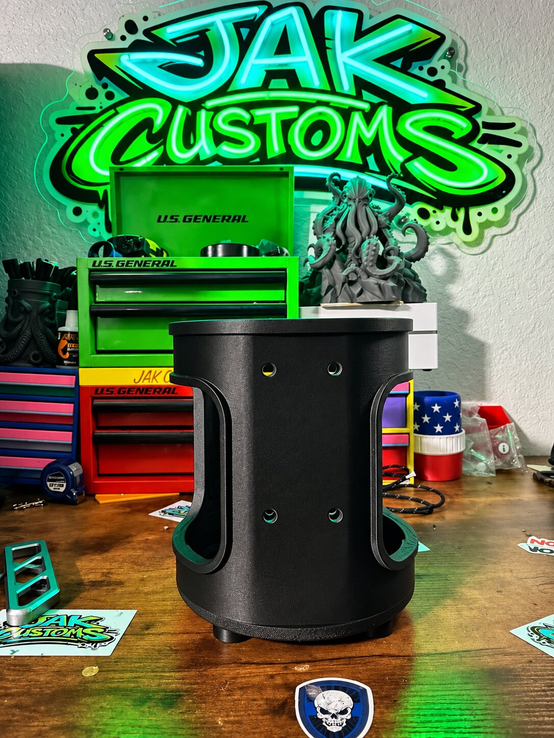 Tall black cylindrical siren cover on the shop workbench