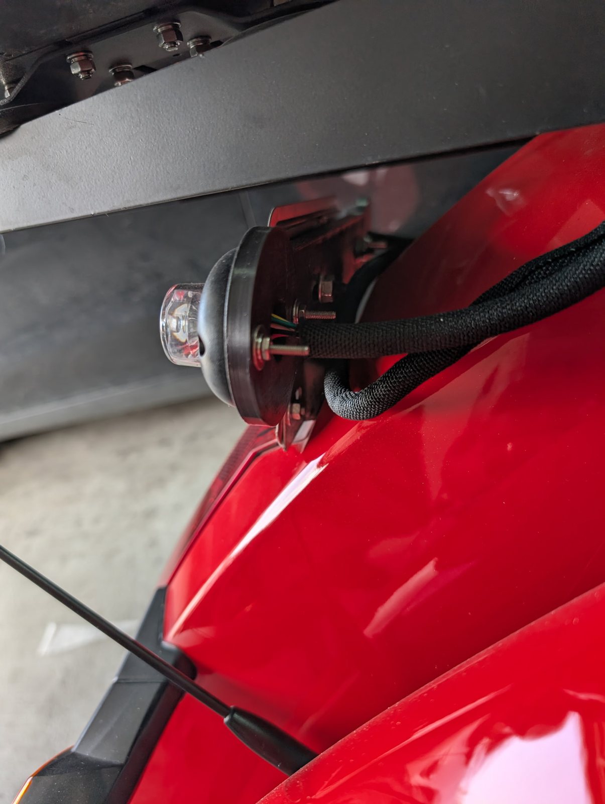Close-up of a fitted part mounted on a red motorcycle