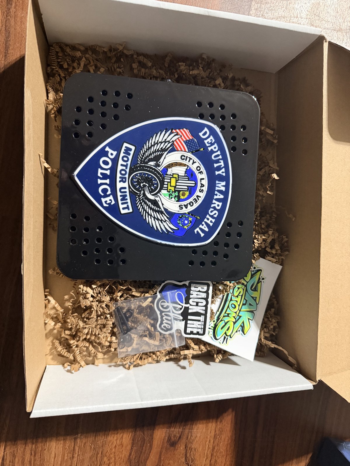Custom shield-shaped police siren cover packaged for shipping