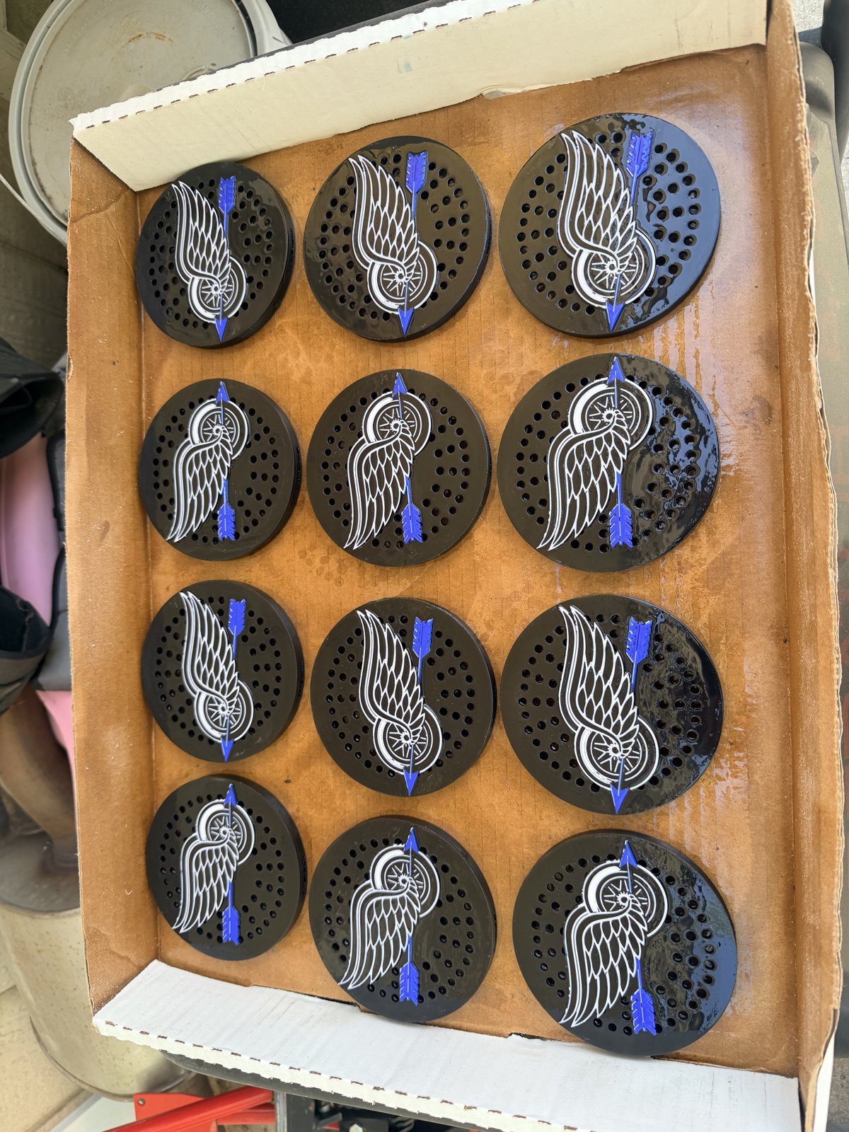 Dozen custom black siren covers with patterned faces in a box