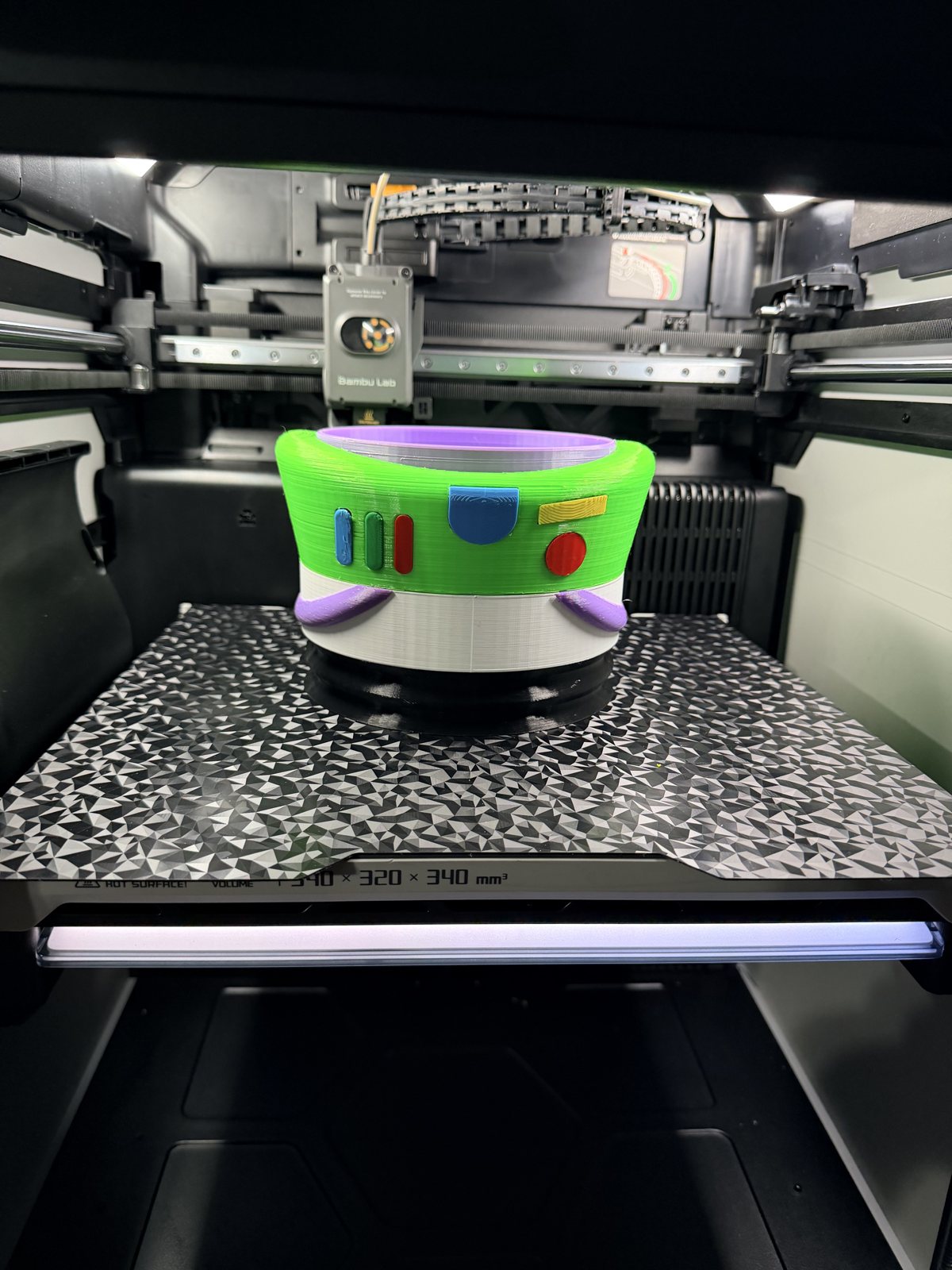 Green and purple printed cylindrical part on a printer bed