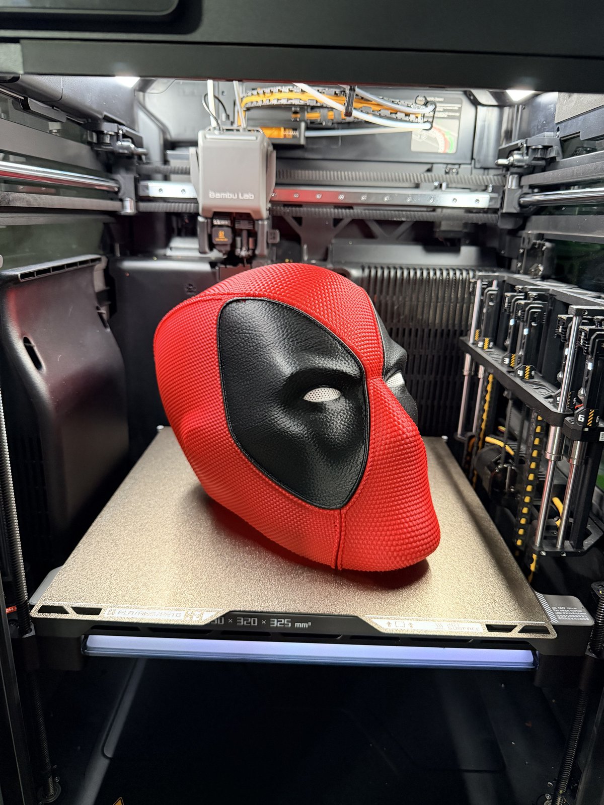 Red and black Deadpool-style mask at an angle on the printer bed