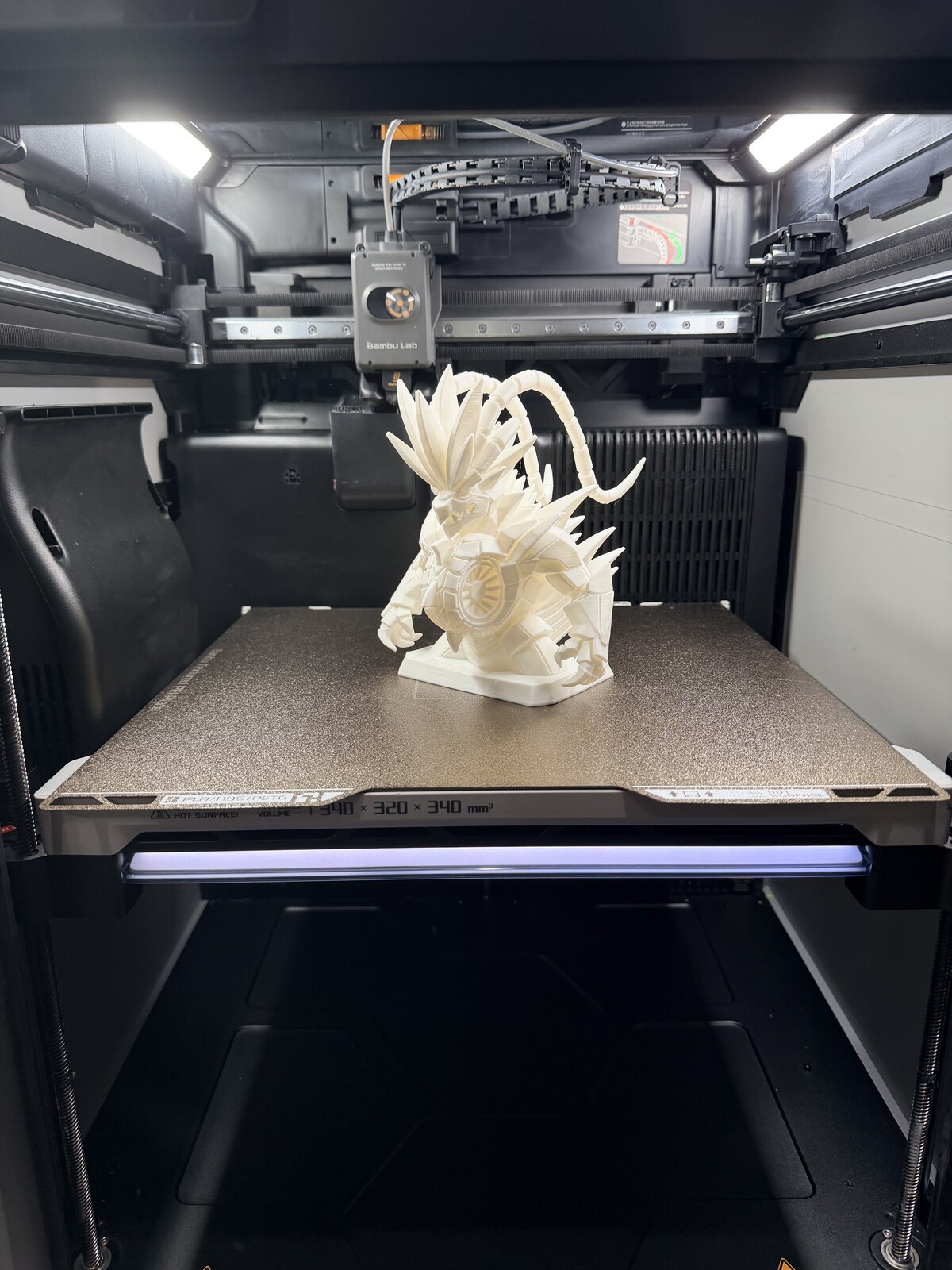 White dragon figure with unfolded wings on the print bed