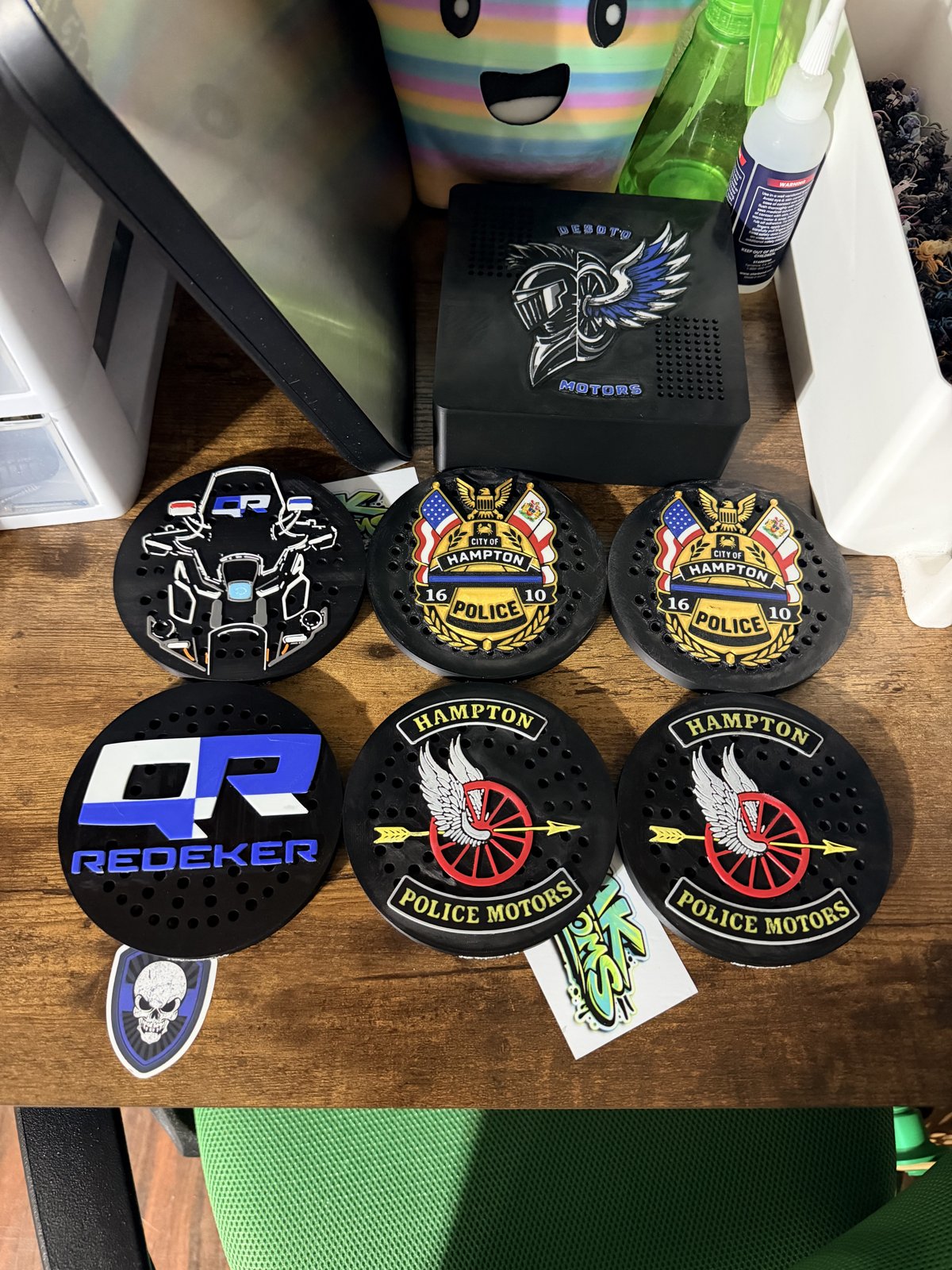 Assorted custom police siren covers and patches on a workbench