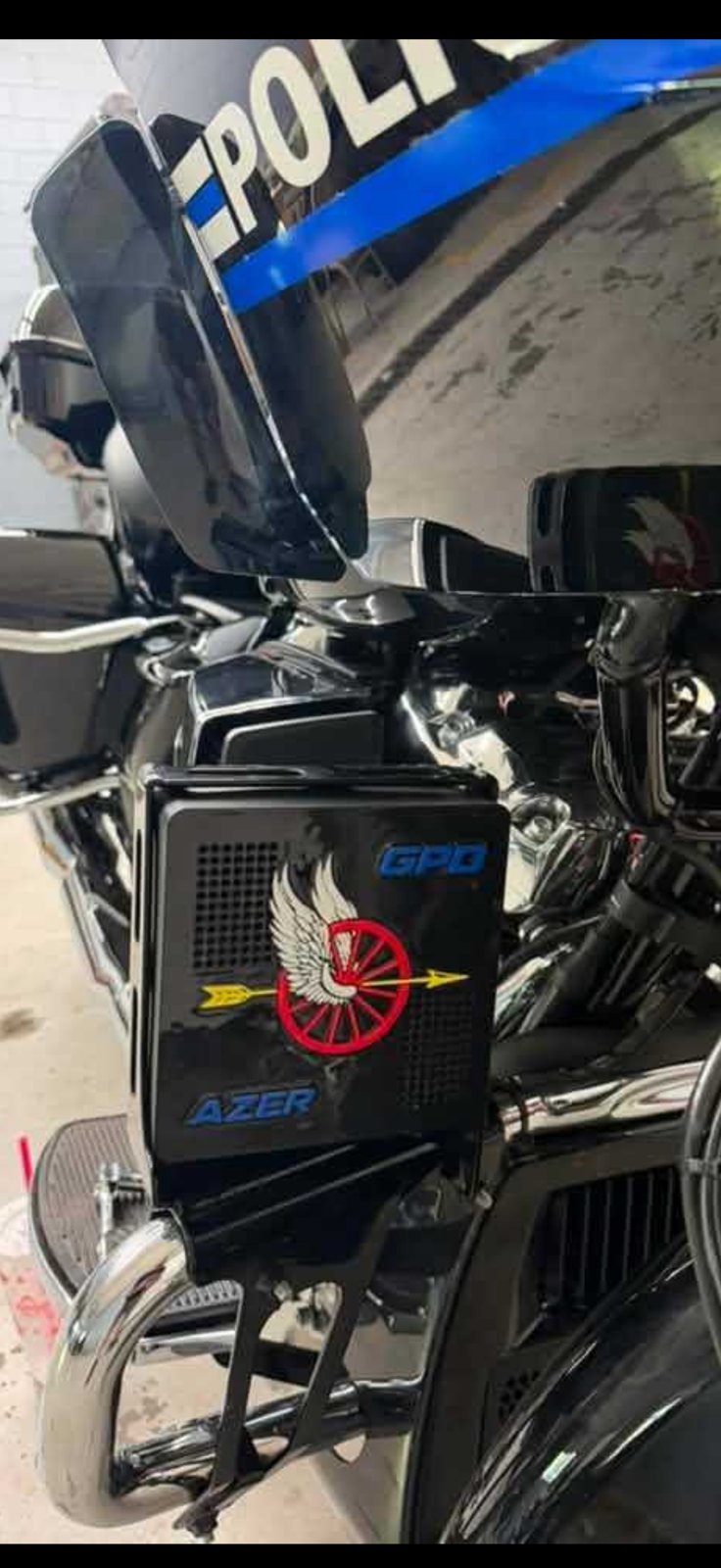 Black police siren cover fitted to the front of a motorcycle