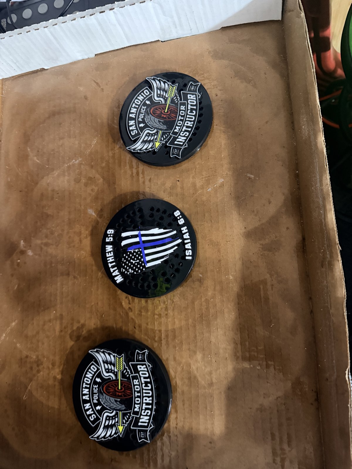 Three custom black siren covers with subdued insignias