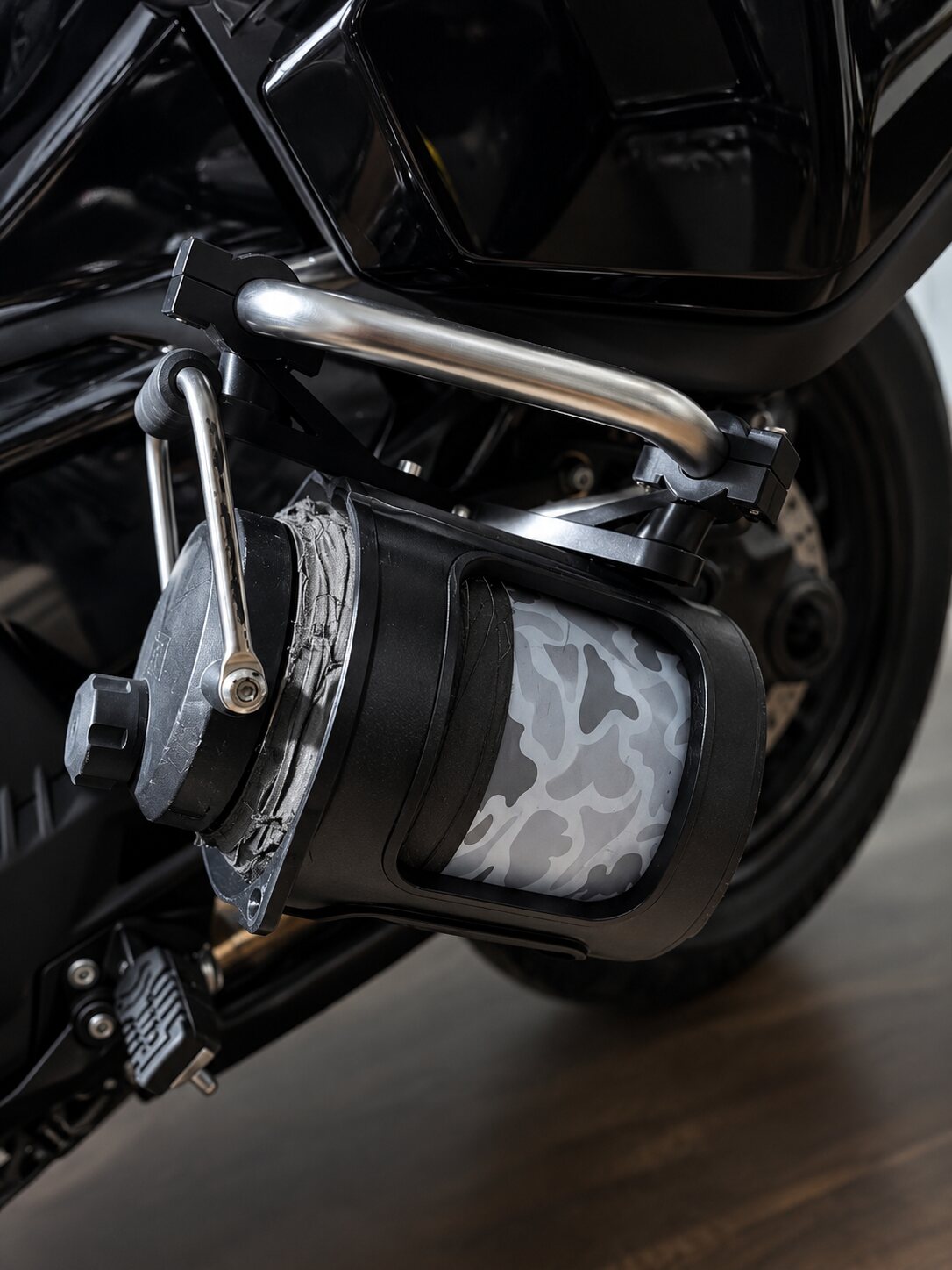 Camo-pattern siren cover mounted low on a police motorcycle